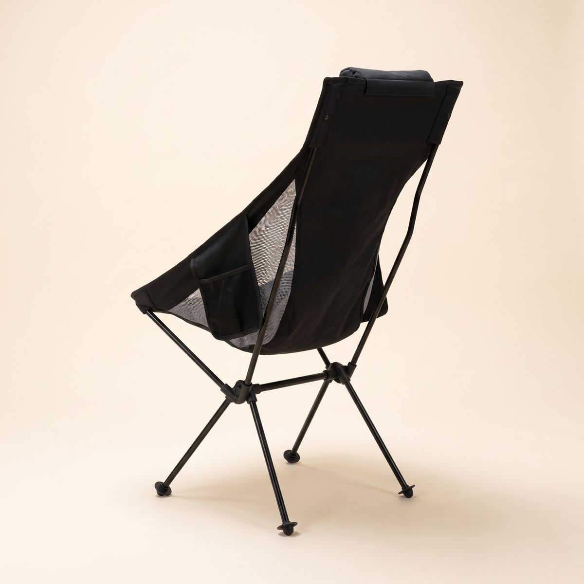 Ultralight high back camping chair in black with headrest on a cream studio background