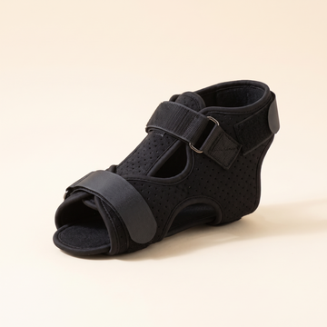 Adjustable dorsal night splint in black on a cream studio background