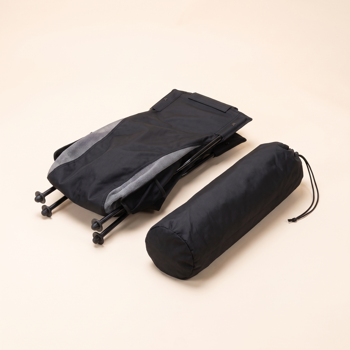 Folded high back camping chair next to its drawstring carry bag