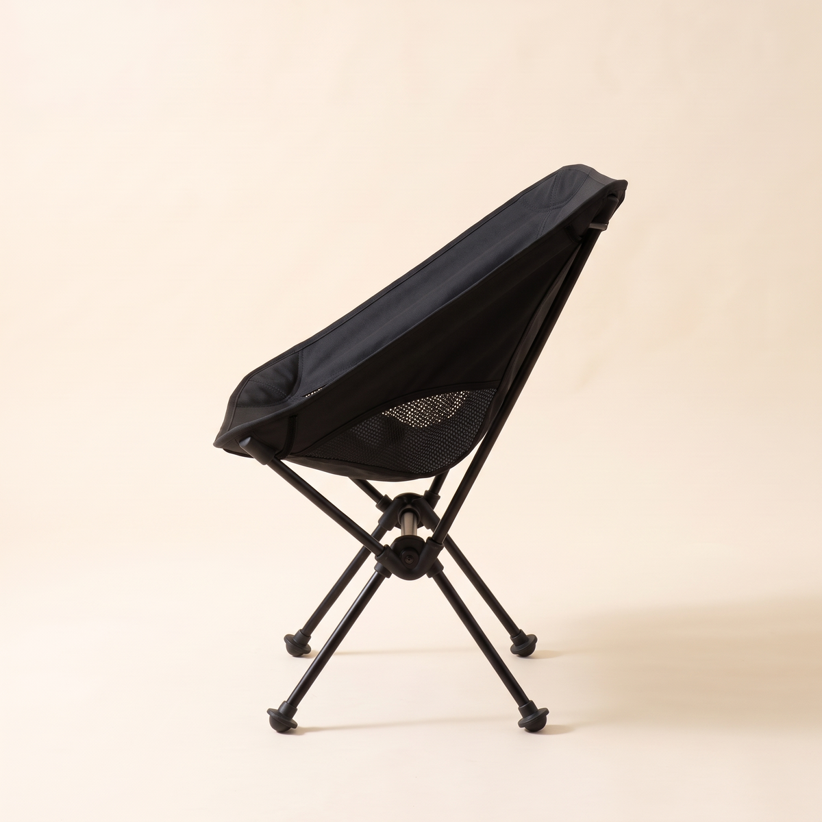 Side view of the compact folding camping chair in black