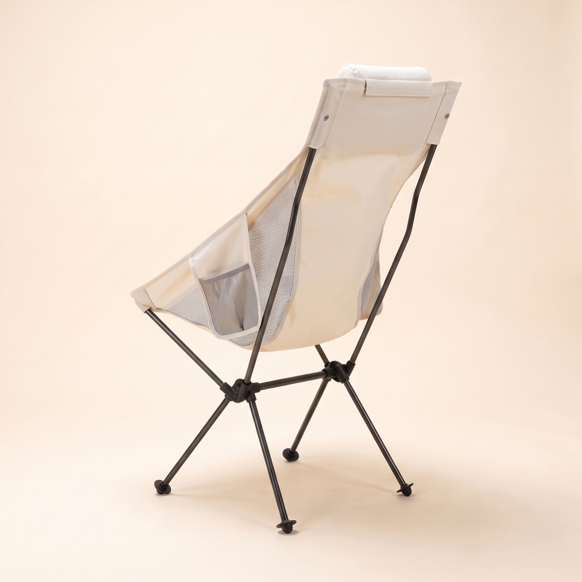 Ultralight high back camping chair in cream with headrest pillow on a studio background