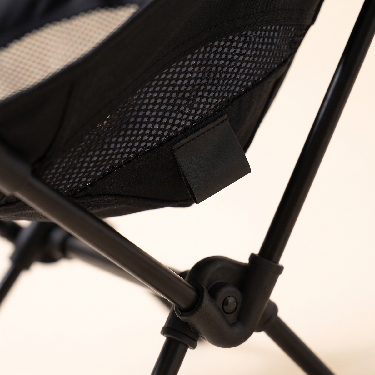 Close up of the aluminum frame joint and mesh detail on the compact camping chair