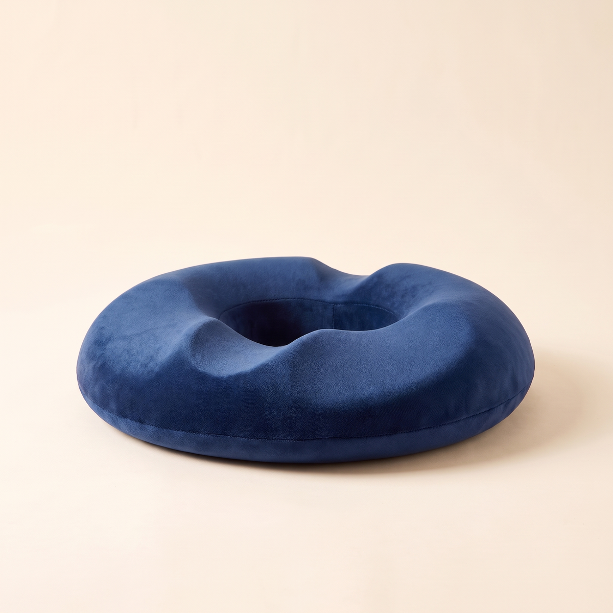 Side view of the memory foam donut seat cushion in navy blue