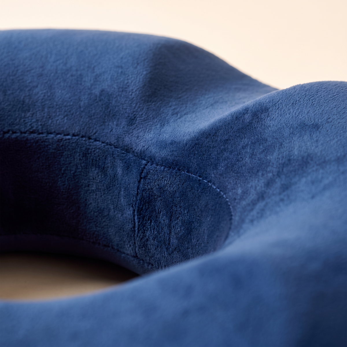 Close up of the soft velvet texture and contoured shape of the donut seat cushion