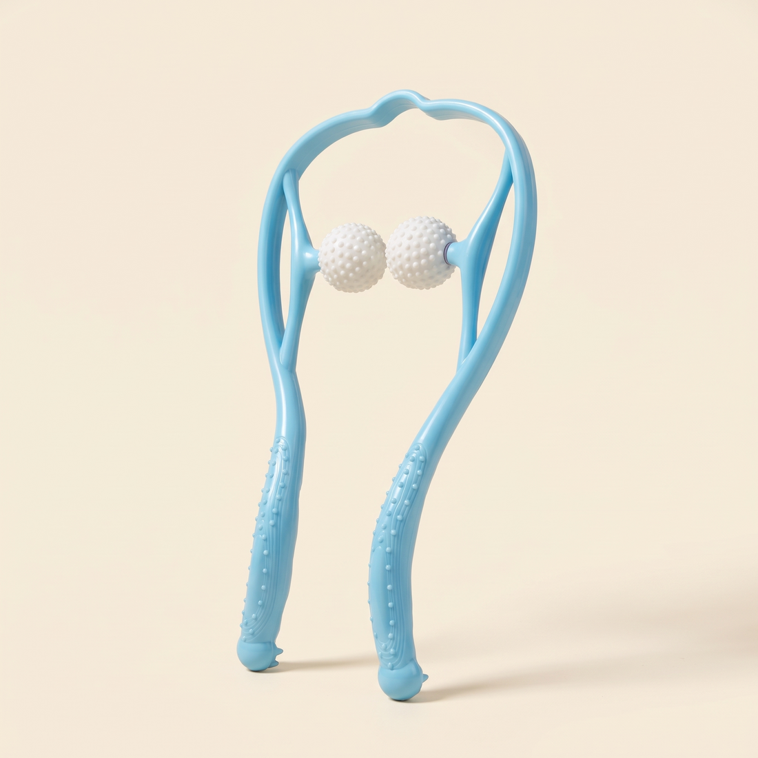 Blue dual point neck massager with two white textured massage balls on a cream studio background