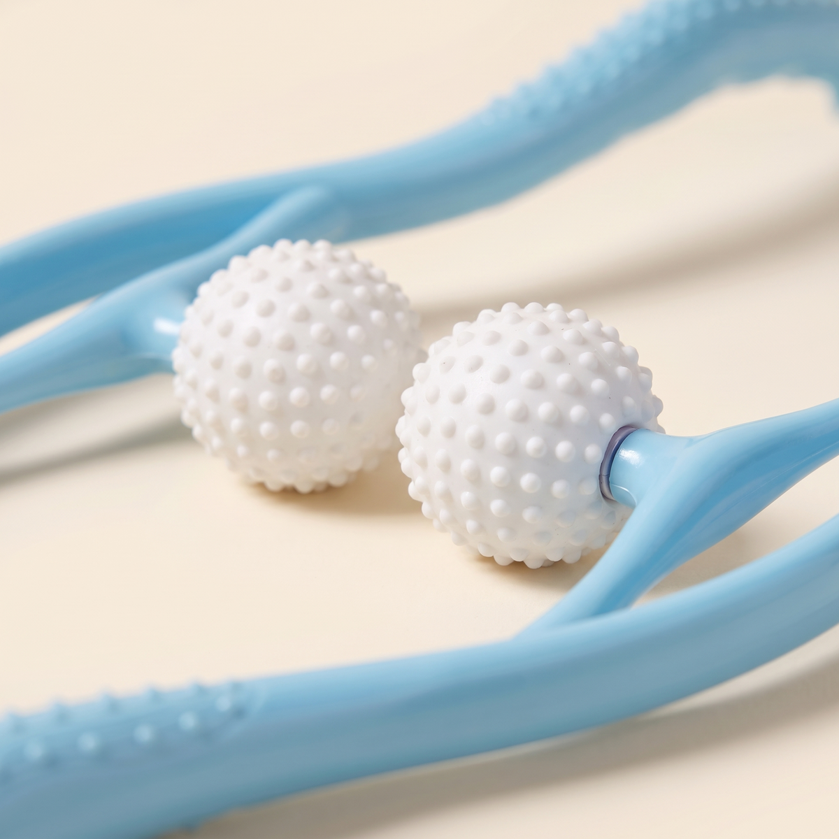 Close up of the white textured silicone massage balls on the neck massager