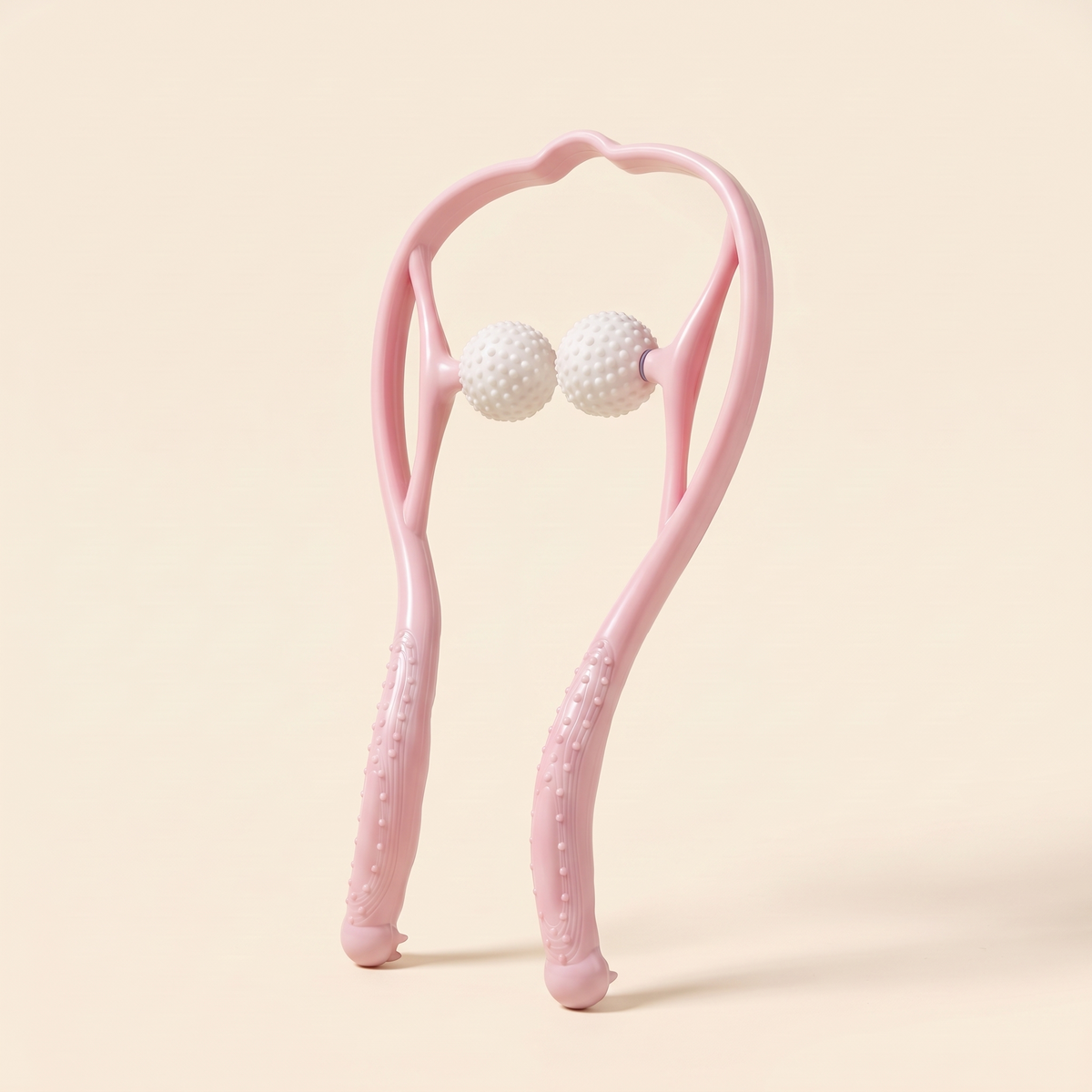 Pink dual point neck massager with two white textured massage balls on a cream studio background