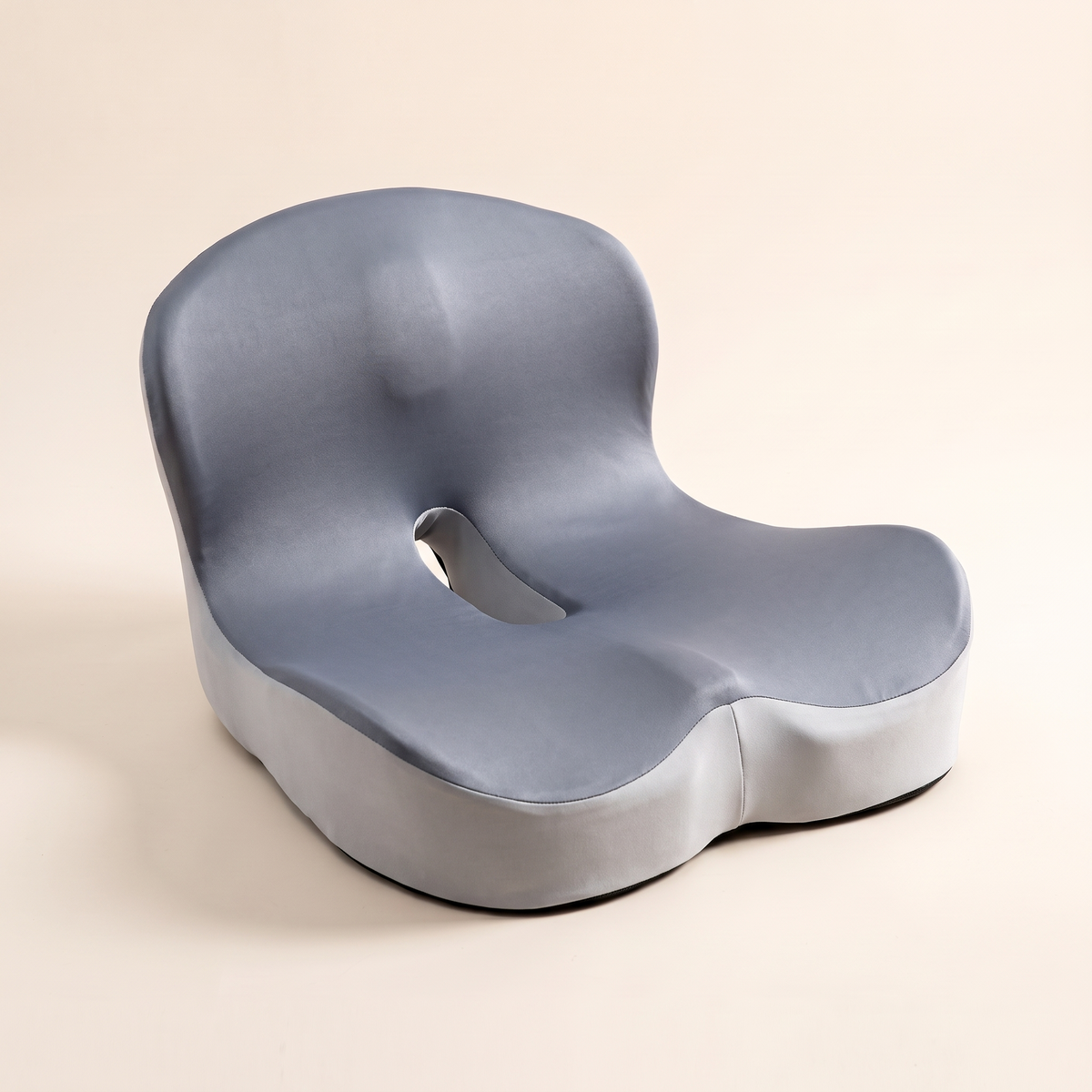 Ergonomic memory foam seat cushion in color blocked gray ice silk on a cream studio background