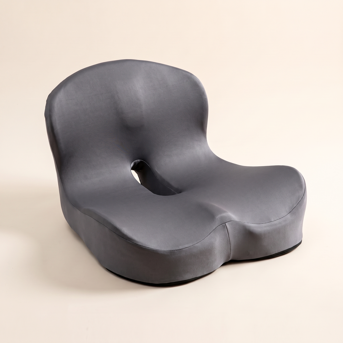 Ergonomic memory foam seat cushion in dark gray ice silk on a cream studio background