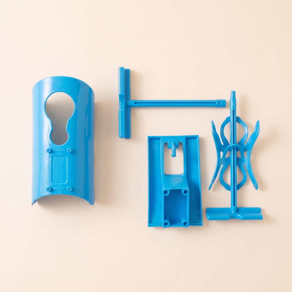 Flat lay of the four plastic parts of the blue sock aid